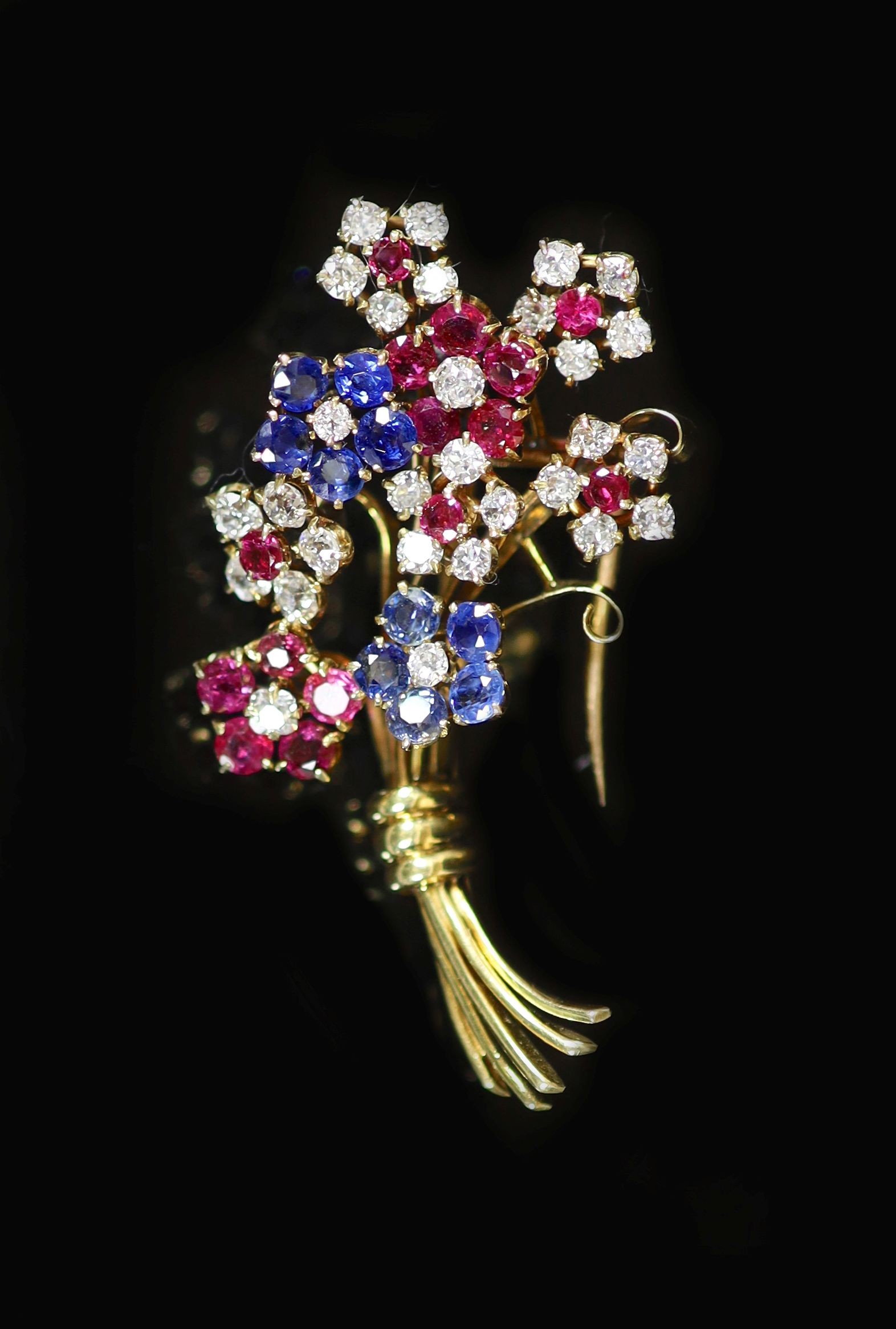 A 20th century French Van Cleef & Arpels 18ct gold, ruby, sapphire and diamond cluster set floral spray clip brooch